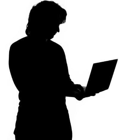 Silhouette of a man holding laptop