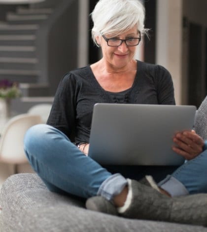Senior woman with her laptop in her comfortable living room