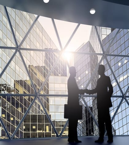 businessman shaking hands inside a business tower