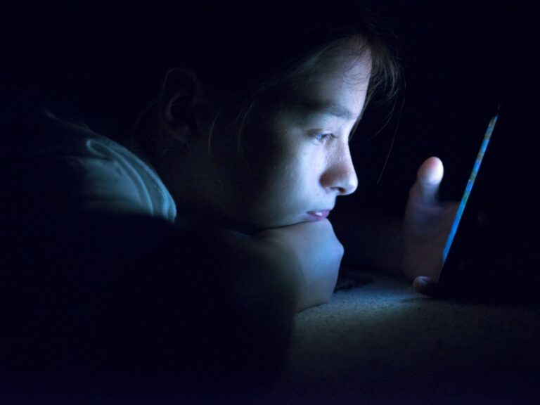 child looking at phone at night