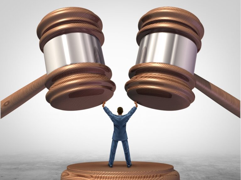 Litigate or arbitrate concept, two gavels coming down on attorney