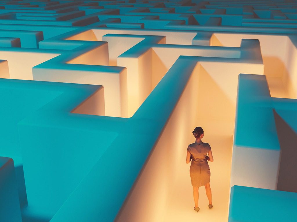 business person looking at lit path in maze, career path concept