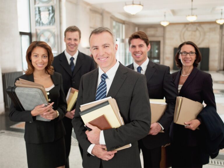smiling-lawyers-holding-files-in-lobby Structuring a High-Performing Legal Ops Team