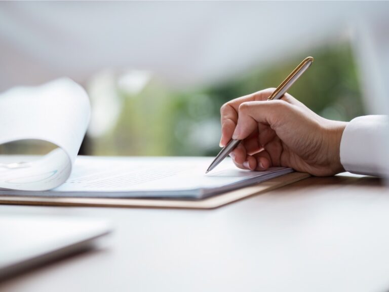 business-agreement-signing-close-up-of-hand-signing-contract-with-pen-on-desk Cybersecurity Executive Order Resets Compliance Expectations for Federal Contractors