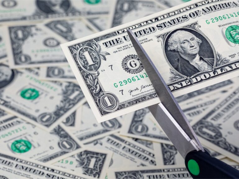 scissors-cutting-a-one-dollar-bill-cash-money-inflation-budget-cuts-and-cost-cutting-concept Budget Cuts and Workforce Reductions Threaten IRS Audits for High-Income Taxpayers