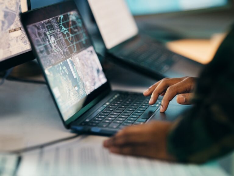 hands-typing-laptop-and-closeup-on-table-of-military-intelligence-map-and-research-on Turning Knowledge Maps into Everyday KM Tools