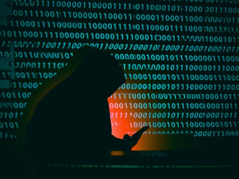 hooded-hacker-silhouette-stealing-data-with-binary-code